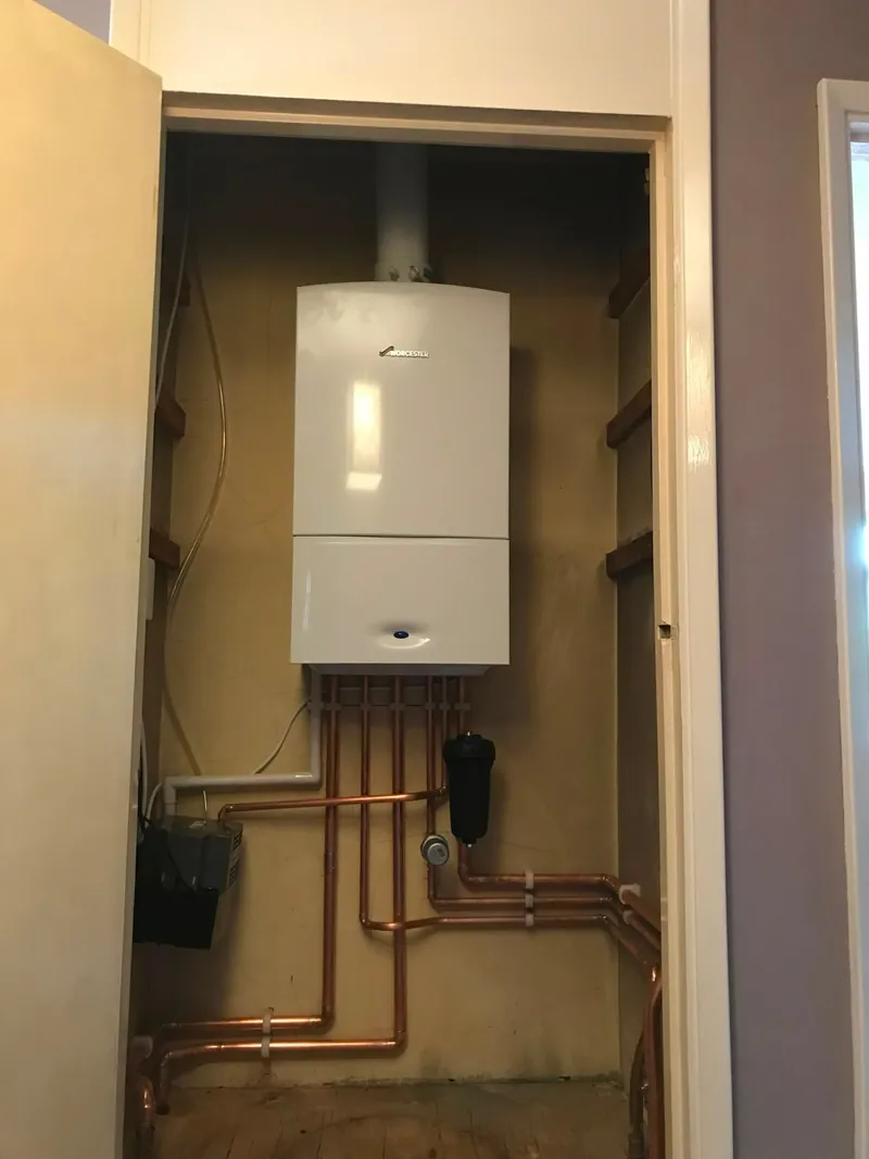 Worcester combi boiler and copper pipework installed in a cupboard