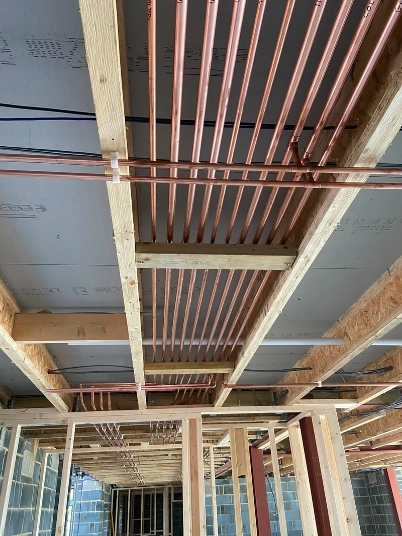 Central heating copper pipework routed through joists in a new build
