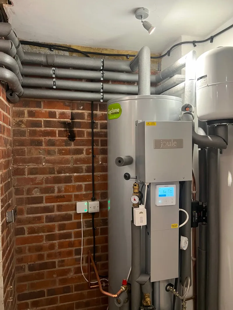 Close-up of heat pump cylinder controller and insulated pipes