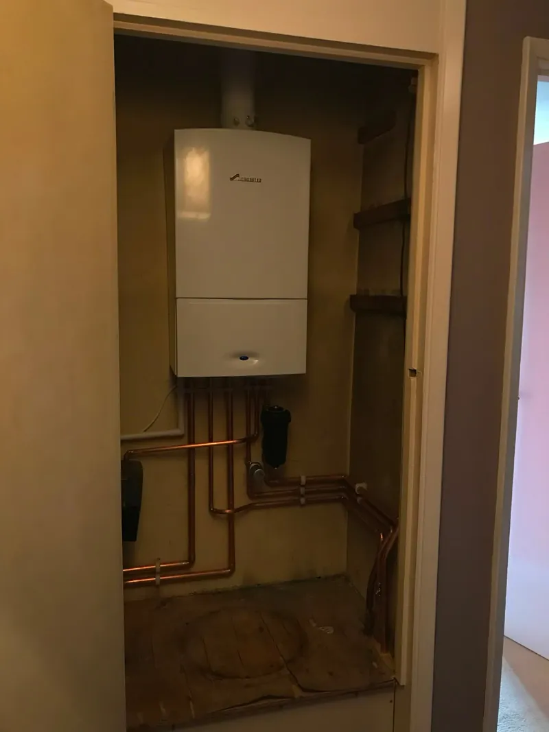 Worcester boiler fitted in a cupboard with exposed copper pipes